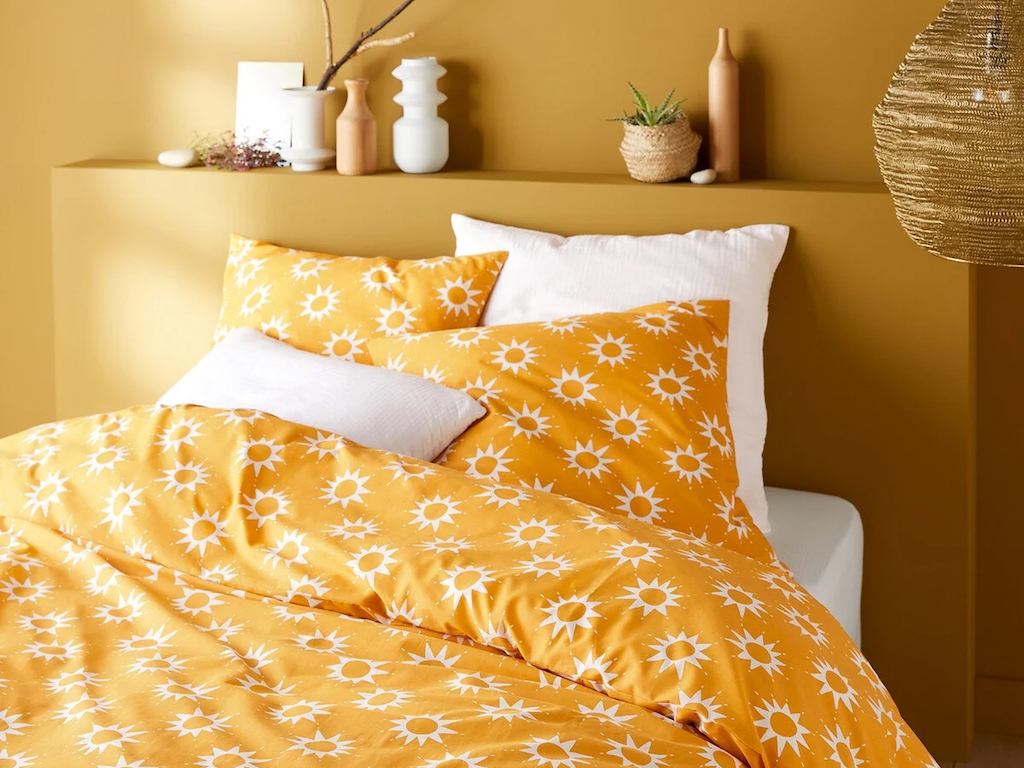 chambre murs jaune et linge de lit à motifs