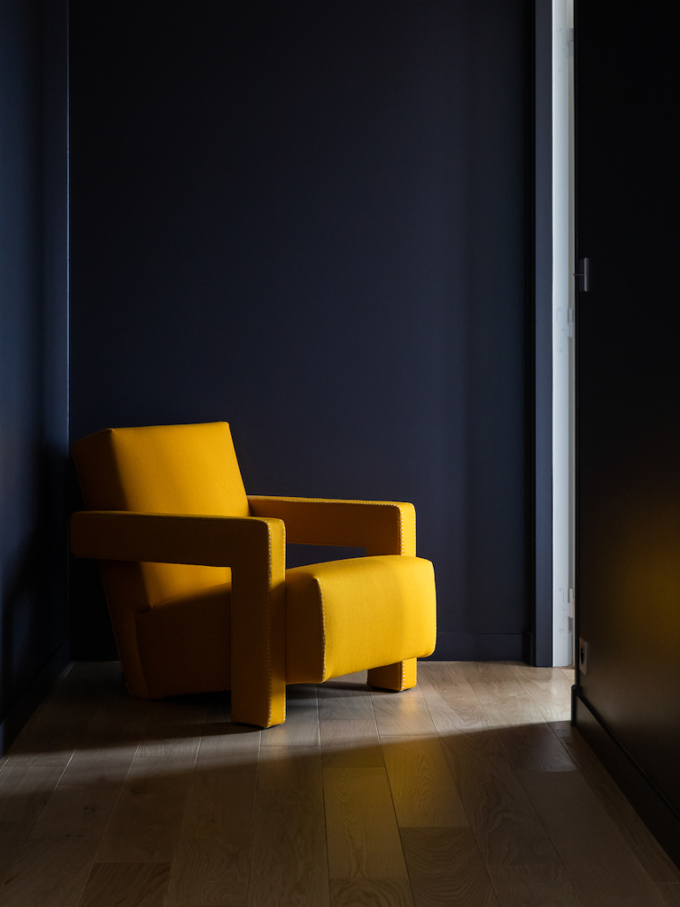 fauteuil jaune et mur noir
